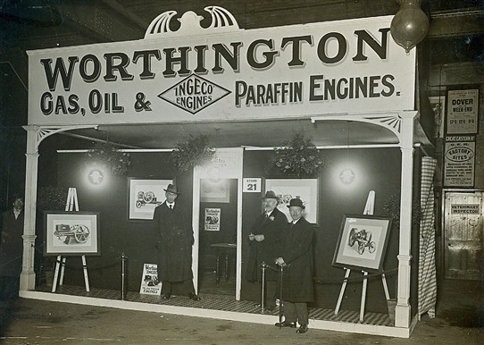 Photo:A photo dated 1916 of a Worthington trade stand featuring advertisements for various tractors